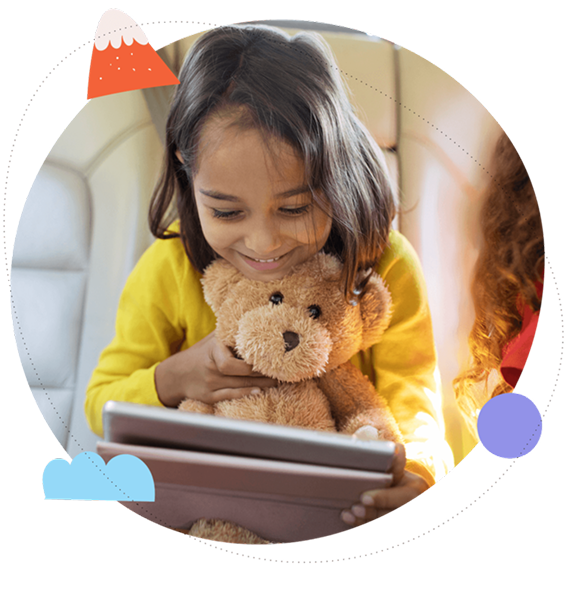 A young girl cuddling a teddy bear while using a tablet in the car.
